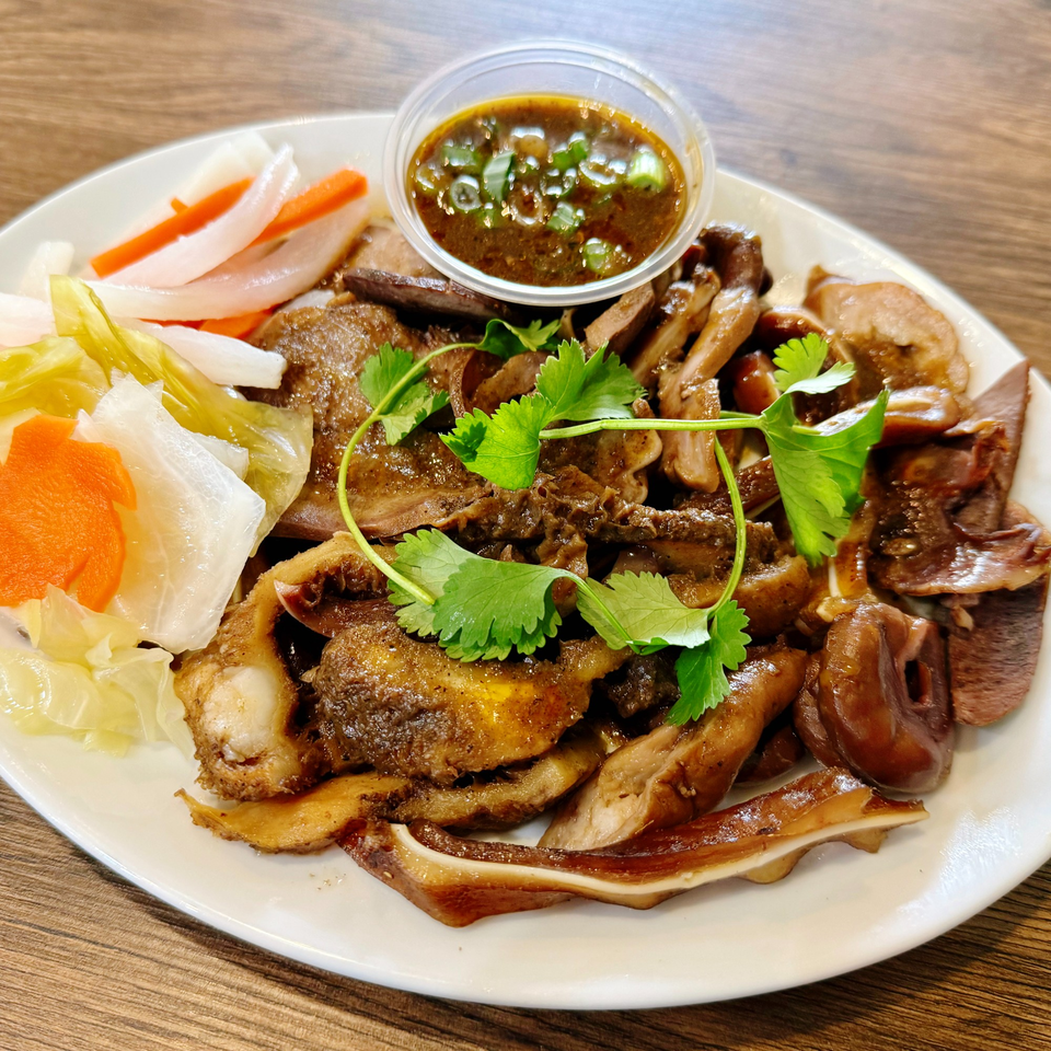 A Vietnamese dish of braised pork offal with pickled vegetables and a side of dipping sauce.